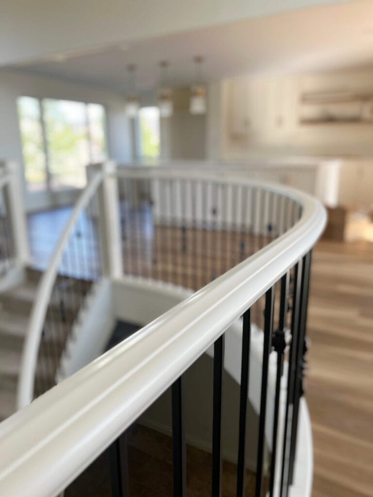 Curved stair railing refinished in white